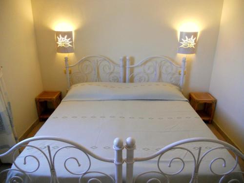 ポルト・サン・パーオロにあるLa Cerbiatta Residenceの白いベッド(上に2つのライト付)