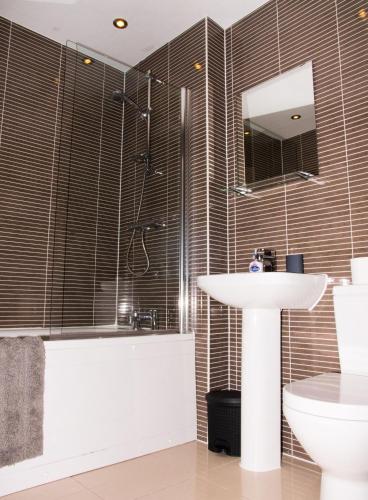 a bathroom with a shower and a sink and a toilet at Impressive Urban Townhouse - Leeds City Centre in Leeds