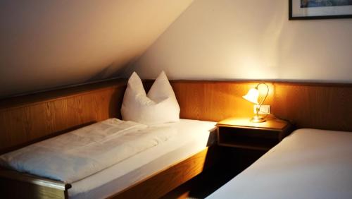 a hotel room with two beds and a lamp at Pension Rupertstubn in Ingolstadt