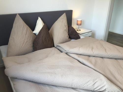 a bed with white sheets and pillows on it at Auszeit in Bell