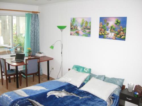 1 dormitorio con cama y mesa con ordenador portátil en Happy Land, en Jūrmala
