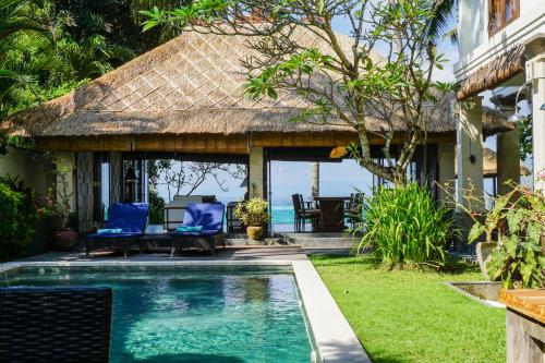 a villa with a swimming pool and a resort at Villa Anjani - Ocean view Villa, With Private Garden and Cook - Candidasa in Candidasa