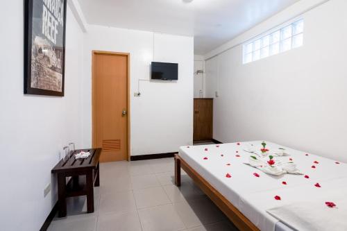 a bedroom with a bed with flowers on it at Scandi Divers in Puerto Galera