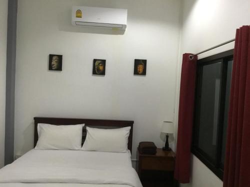 a bedroom with a bed with three pictures on the wall at Jamie's home with 2 bedrooms, can accommodate 6 guests in Ko Samed