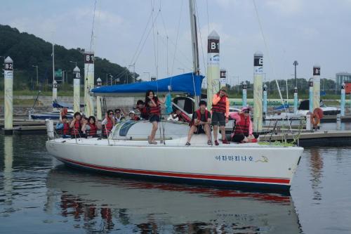 a group of people on a sail boat in the water at Ramada Encore by Wyndham Gimpo Han River Hotel in Gimpo