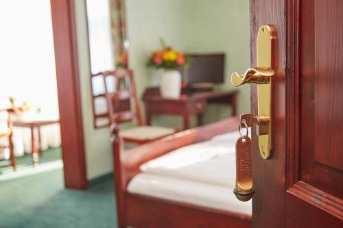 een open deur naar een slaapkamer met een bed en een bureau bij Flair-Hotel Waldfrieden in Meuselbach-Schwarzmühle