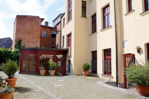 a courtyard of a building with potted plants at Hotel Reutterhaus in Gardelegen