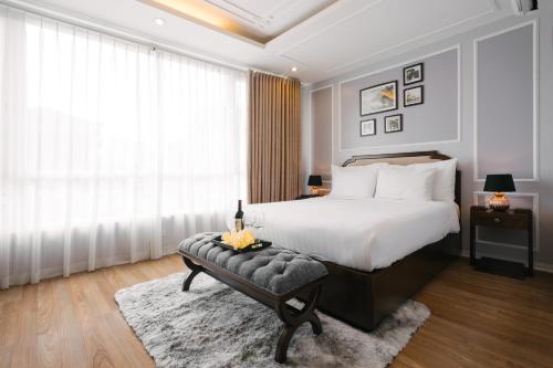 a bedroom with a bed and a chair and a window at La Palm Hotel in Hanoi