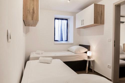 a small room with two beds and a window at Apartments Ivana in Koper
