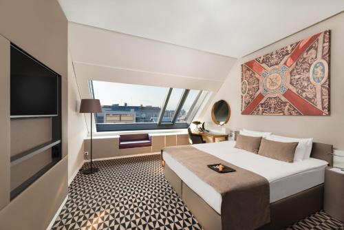 a living room with a white couch and a large window at Hotel Moments Budapest in Budapest