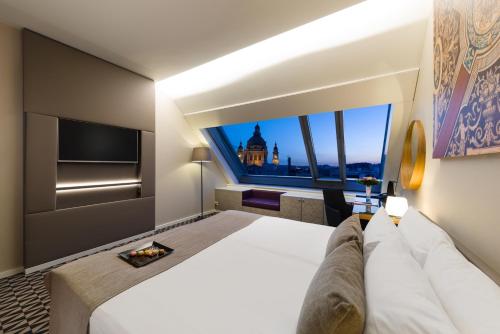 a hotel room with a large bed and a large window at Hotel Moments Budapest by Continental Group in Budapest