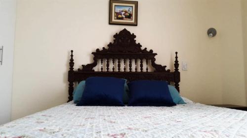 Una cama con dos almohadas azules encima. en Departamento de estreno Pueblo Libre, en Lima