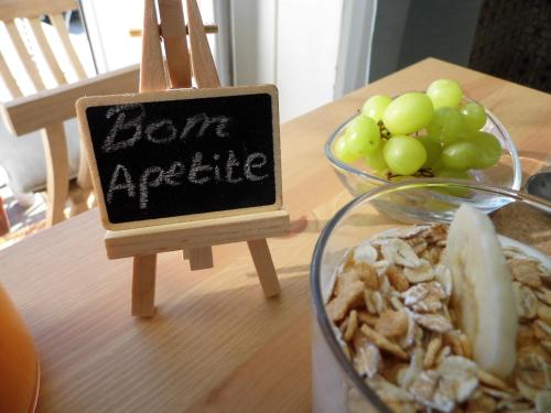 a sign on a table with a bowl of grapes at Bea's Bed & Breakfast in Tavira