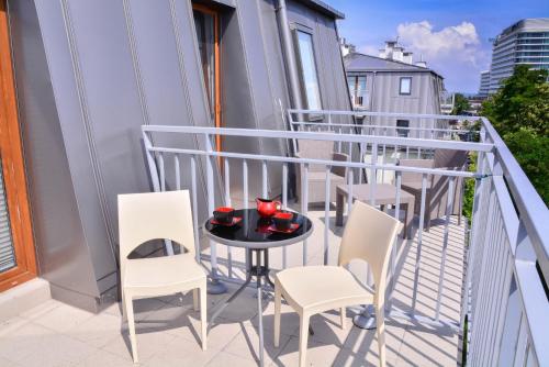 a balcony with a table and chairs on it at Apartamenty na Wyspie - Aquamarina - Budynek A - B - C in Świnoujście