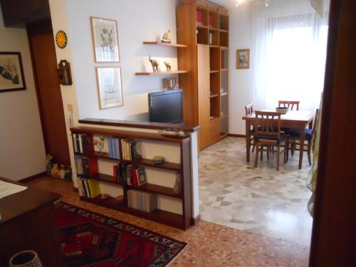 un soggiorno con tavolo e libreria di Appartamento Elisabetta a Lido di Venezia