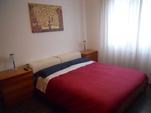 una camera con un letto con una coperta rossa di Appartamento Elisabetta a Lido di Venezia