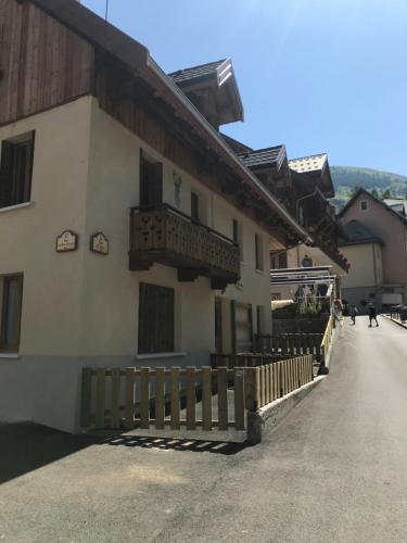 a building with a wooden fence next to a street at Charmant Appartement Centre Ville Valloire in Valloire