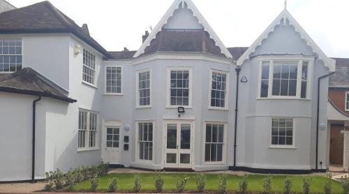 a white house with large windows at Lower Brook Mews in Ipswich