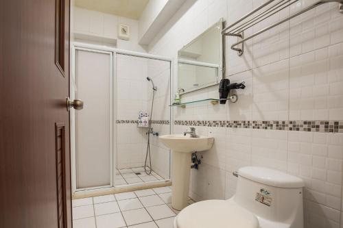 a bathroom with a toilet and a shower and a sink at Jing Dian Homestay in Taitung City