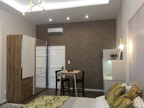 a small room with a table and a bed and a table at Visit Debrecen Apartman in Debrecen