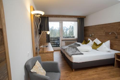 une chambre d'hôtel avec deux lits et une chaise dans l'établissement Gästehaus Wildbach, à Mittelberg