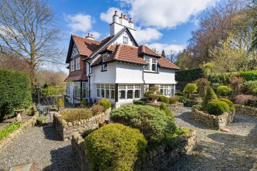 a house with a garden in front of it at Storrs Gate House in Bowness-on-Windermere