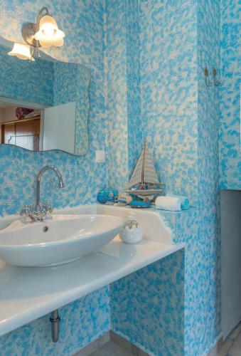a bathroom with a sink and a boat on the wall at The Rock & The Lemon Tree in Sitia