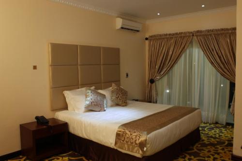 a hotel room with a large bed and a window at Open House Boutique in Manzini