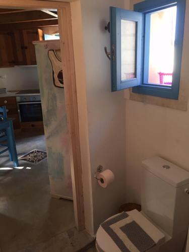 a bathroom with a toilet and a window and a door at Villa Antonia in Almirida