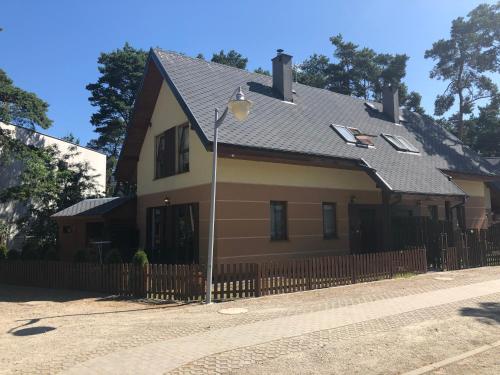 a house with a fence and a street light at Piękny duży dom 300m od plaży in Międzywodzie