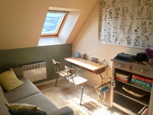 ein Wohnzimmer mit einem Sofa und einem Tisch in der Unterkunft Le Clos Charmaine in Auquemesnil