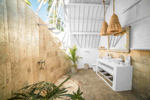 a bathroom with a white sink and a mirror at 7SEAS Cottages in Gili Air