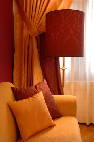 a couch with pillows and a lamp in a room at Appartement-Hotel an der Riemergasse in Vienna