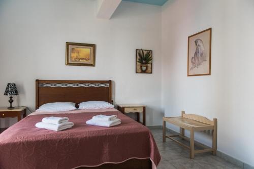 a bedroom with a bed, table, and a painting on the wall at Sea View in Loutraki