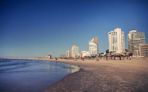 a beach with tall buildings in the background at Wom Allenby Pod Hotel in Tel Aviv