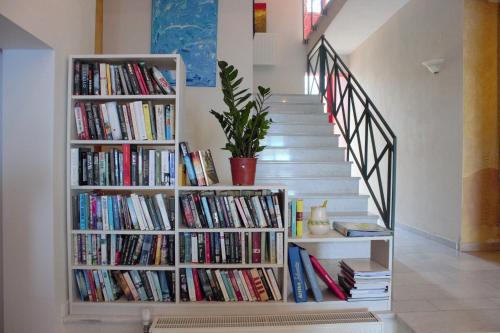 a staircase with a book shelf filled with books at Palatino Hotel in Parga