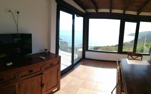 a living room with a television and a balcony at Il Moro in Geremèas