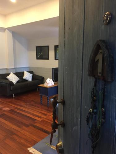 a door to a living room with a couch at P.O.E Posh Homestay in Cha Am