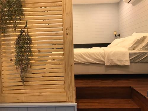 a bedroom with a bed and a wooden wall at P.O.E Posh Homestay in Cha Am
