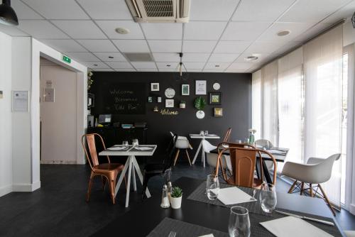 a dining room with two tables and chairs at Clarion Aparthotel Toulouse Le Parc de l'Escale in Toulouse