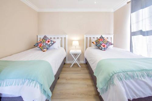 two twin beds in a room with a window at Seacrest Cottage in Knysna