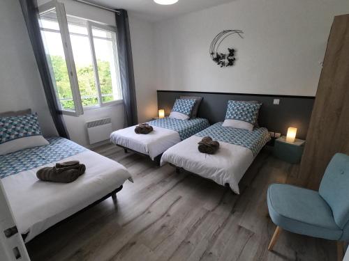 Zimmer mit 3 Betten und einem blauen Stuhl in der Unterkunft côté chêne in Puycornet