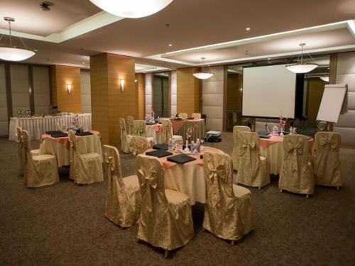 a banquet room with tables and chairs and a screen at Executives Hotel - Olaya in Riyadh