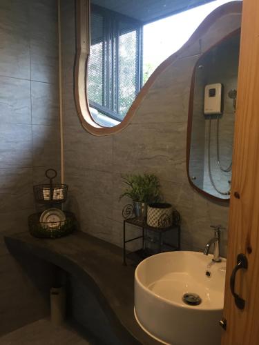 a bathroom with a sink and a mirror at P.O.E Posh Homestay in Cha Am