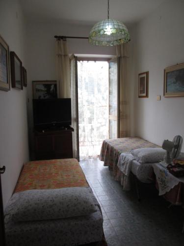 Habitación con 2 camas, TV y ventana. en Casa Marcella, en La Spezia