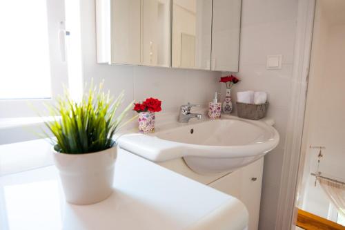 baño blanco con lavabo y encimera blanca en Nicopolis Villa1, en Vrachos