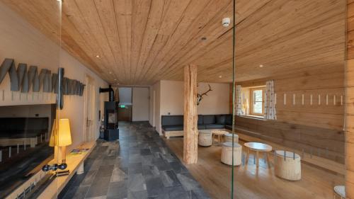 un soggiorno con soffitto in legno e parete in vetro di alpen select lodge Kleinwalsertal a Riezlern