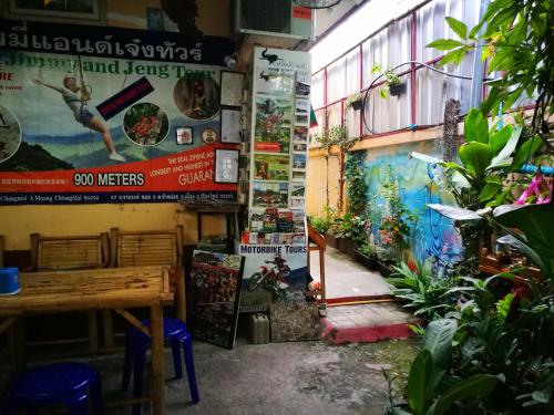 a restaurant with a wooden table and some plants at Jimmy and Jeng Homestay in Chiang Mai