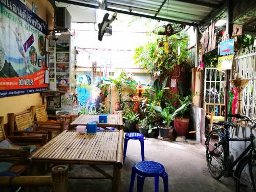 a room with two wooden tables and chairs and plants at Jimmy and Jeng Homestay in Chiang Mai