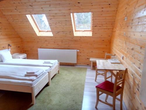 Sîntimbru-Băi的住宿－Mofetta Panzió，客房设有两张床、一张桌子和窗户。